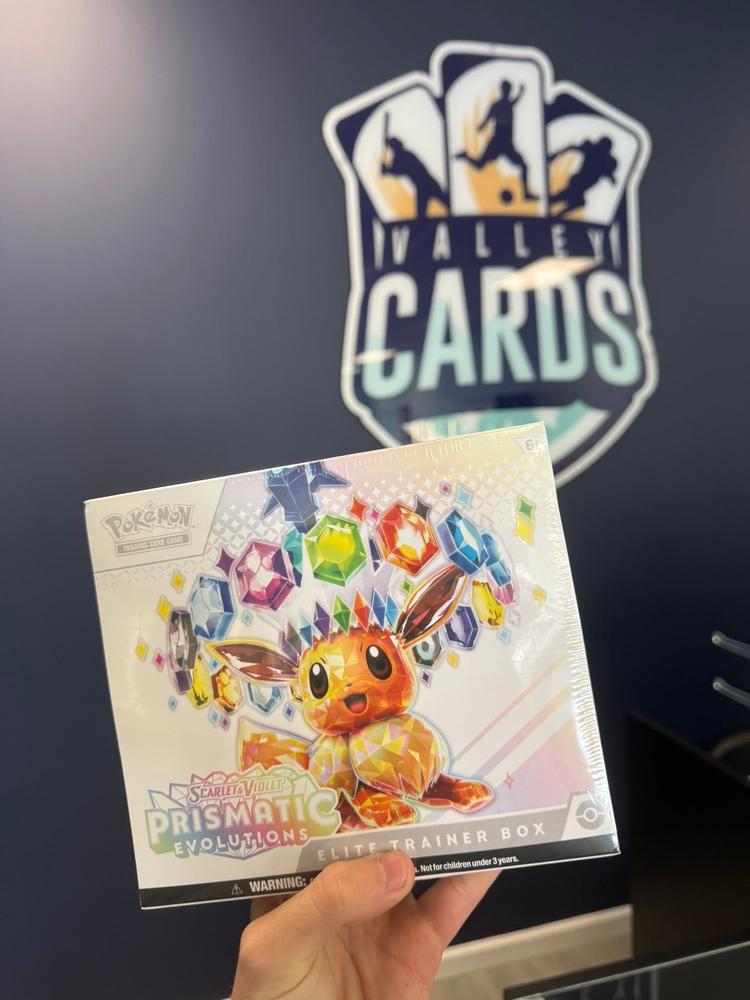 Sealed Pokemon trading card product held in front of the Valley Cards logo